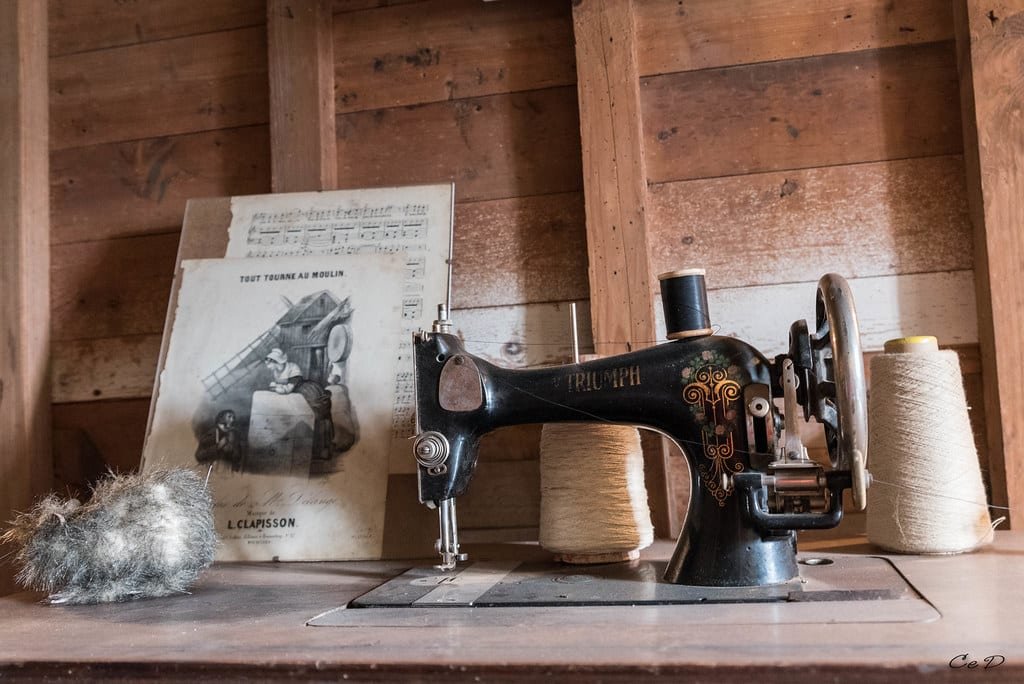 Ancienne machine à coudre sur un établi en bois